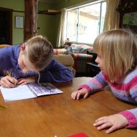 Poppy helping Mahalia write a story about mustering